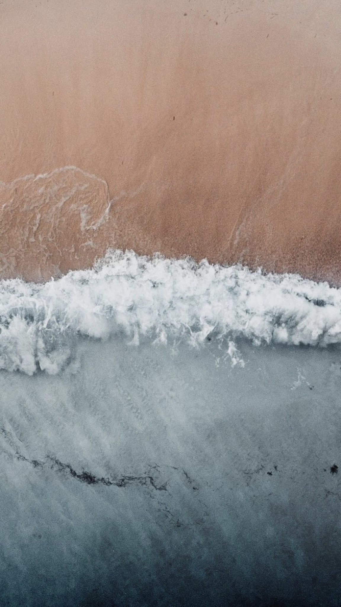 Download Aerial Ocean Waves Meeting Sandy Beach in ultra HD 4K resolution for desktop, iPhone and Android devices.